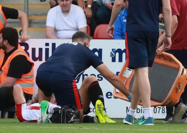 Jordon Forster lies in agony after rupturing his Achilles. Pics: Thousand Word Media/GloucestershireLive