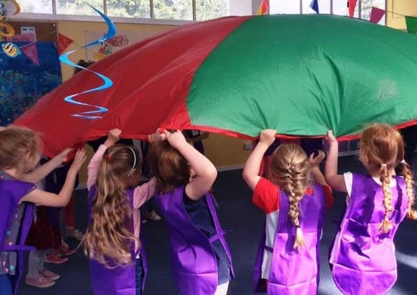 Rainbows in Bonnyrigg, pictured playing a parachute game, are desperate for more volunteer helpers.