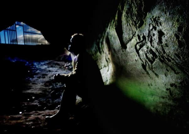Inside Jonathan's Cave with a Pictish carving clearly on show. The gate is no longer in place. 

PIC PHIL WILKINSON / TSPL.