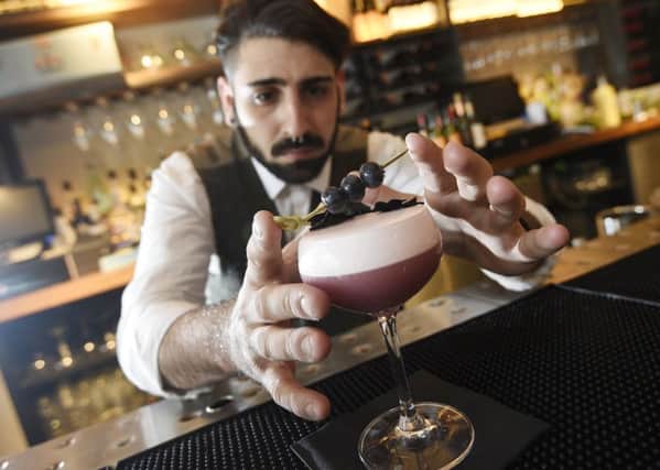 Bar Supervisor Angelo Franchi makes a Violet Beauregarde which is a Willy Wonka inspired cocktail at The Refinery in St Andrew Square. Picture: Greg Macvean