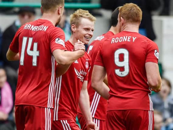 Aberdeen's Gary Mackay-Steven is congratulated by team-mates Kari Arnason and Adam Rooney on his opening goal at Easter Road.