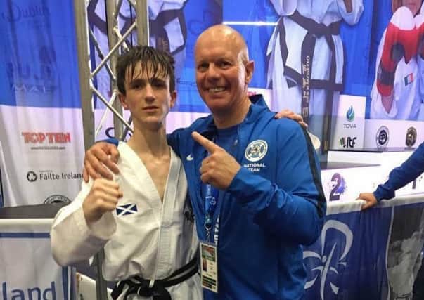 15-year-old Ian Ford has become the first male world TaeKwon-Do champion in 20 years. Pictured with coach Robin Blair. Picture: contributed