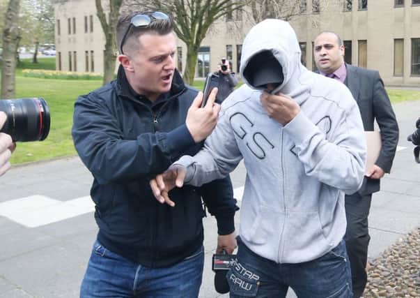 Former EDL leader Tommy Robinson (centre) films an unidentified man arriving at Huddersfield Magistrates Court