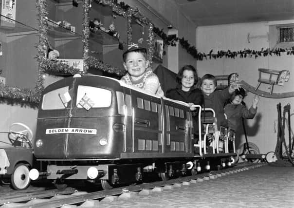 Children play on the model of the Golden Arrow engine in Jenners, Edinburgh, November 1965