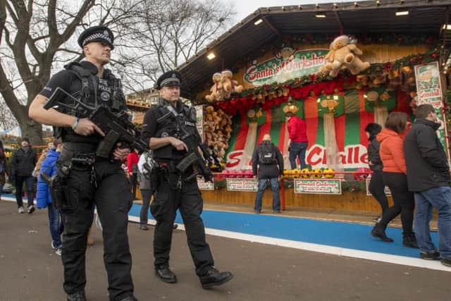 Armed Police on patrol and concrete bollards at Edinburgh Christmas Market in Princes Street Gardens.
