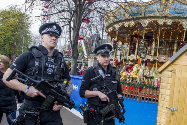 Armed Police on patrol and concrete bollards  at Edinburgh Christmas Market in Princes Street Gardens