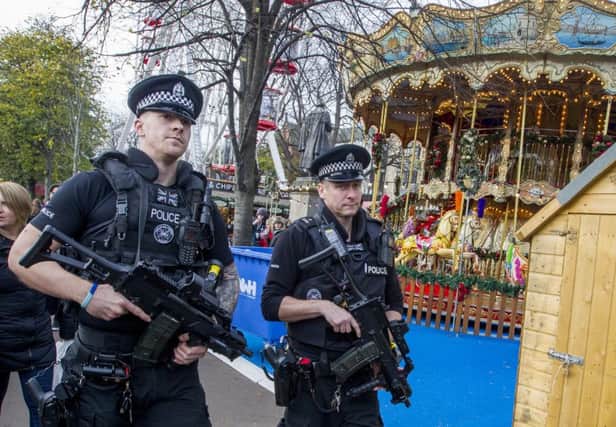 Armed Police on patrol and concrete bollards  at Edinburgh Christmas Market in Princes Street Gardens