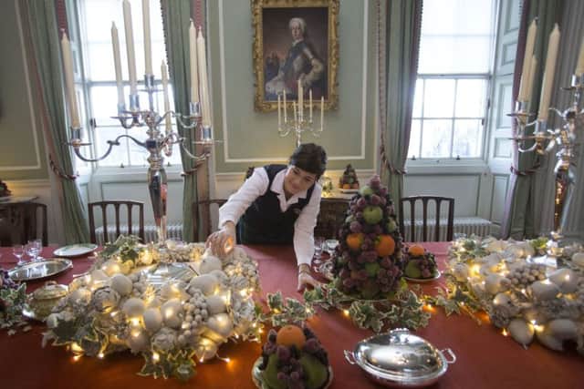 Staff member Maria Perez helps with the Christmas preparations underway at the Palace of Holyroodhouse,Edinburgh where the State Apartments have been transformed with glittering Christmas trees, twinkling lights and a dining table laid for a royal feast. In the Great Gallery a 15-foot-high Christmas tree is decked in white and silver, while in the Royal Dining Room the table is laid with pieces from a silver service presented to George V and Queen Mary in 1935 to mark their Silver Jubilee. Christmas at the Palace of Holyroodhouse is from 1 December 2017 to 5 January 2018.Photograph David Cheskin Royal Collection.01.12.2017