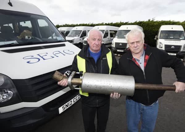 SEAG drivers Jim Harcourt and Stewart Mitchell with some of the exhausts which were ripped out of their minibuses. Picture: Greg Macvean