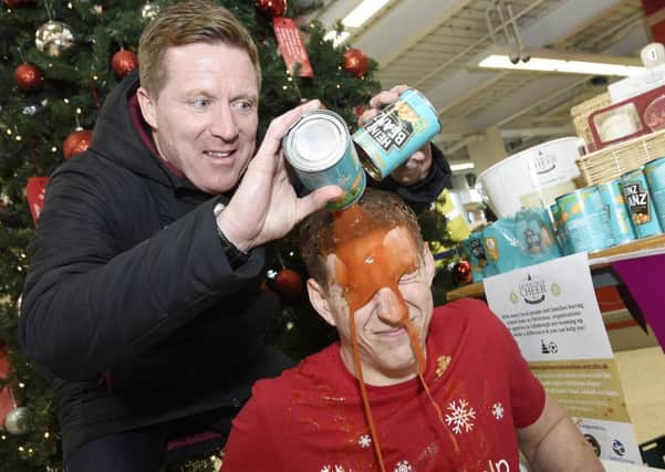 Hearts ex player and manager Gary Locke at Tesco Corstorphine where he pours a tin of beans over David Whelan for the Christmas Cheer appeal