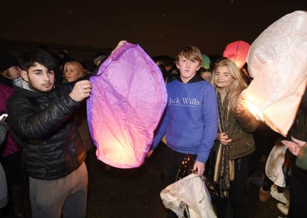 Liam's brother Josh, centre, with Aaron Tuncay and Lauren Muir join the crowds to light lanterns for Liam. Picture: Greg Macvean