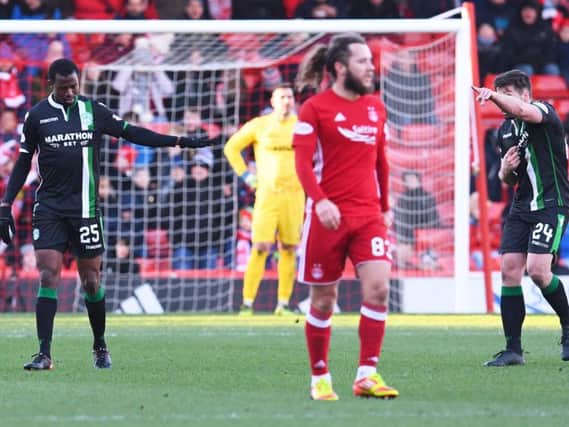 Hibs defender Efe Ambrose apologises to Darren McGregor after the Nigerian's slip led to Aberdeen's third goal