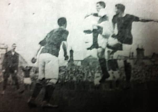 Rangers player Reid (white shirt) challenges Paterson
