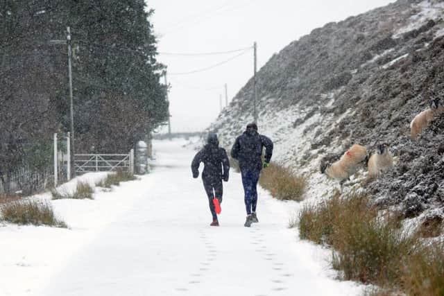 Runners in the snow in the Pentland Hills Regional Park near Flotterstone. Picture: Jane Barlow