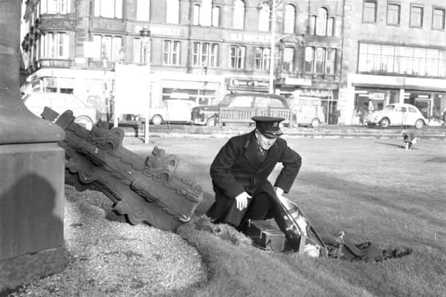 A policeman inspects the damage to Princes Street Gardens after a floodlight and stonework are dislodged from the Scott Monument by the January gales in 1968 Picture: TSPL