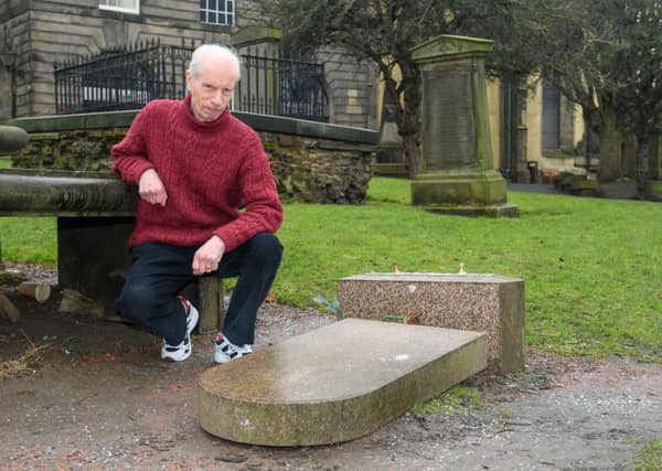 Bert Hutchings, kirkyard tour guide, next to the stone.