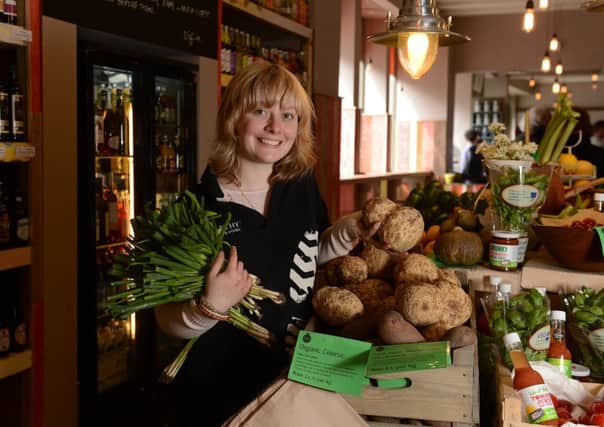 An earthy staff member with some of the store's locally sourced organic produce