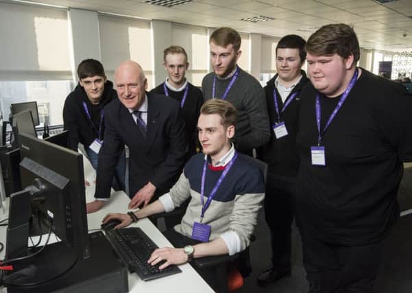 Craig Laidlaw gets to work as MSP Joe FitzPatrick and the other graduates of the work placement scheme look on. Picture: Alan Richardson