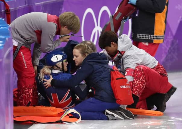 Elise Christie receives treatment before being stretchered off after crashing in Saturdays 1500m semi-final