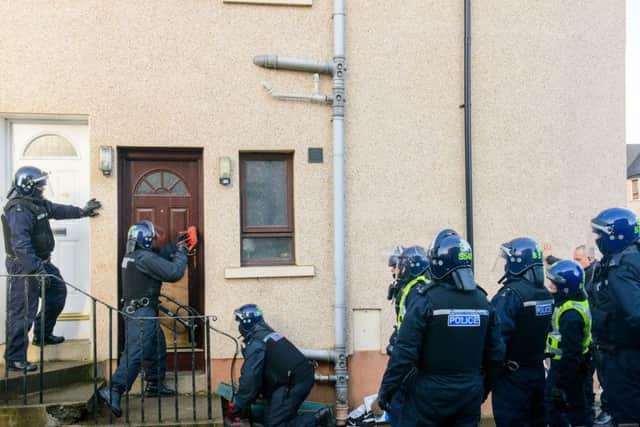 Officers force their way into a property in Blackburn