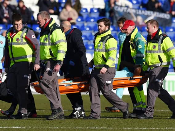 Hearts midfielder Arnaud Djoum is stretchered off in pain