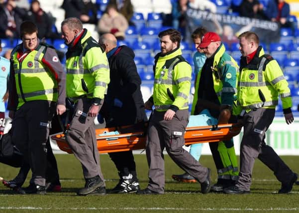Hearts midfielder Arnaud Djoum is stretchered off after 25 minutes in Dingwall. Pic: SNS
