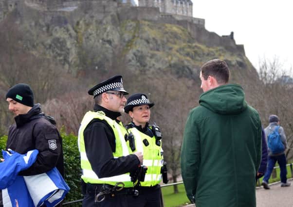 Police question people in Princes Street Gardens yesterday. Picture: Jon Savage