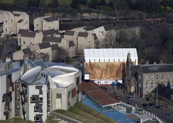 The nine-metre high decorative scaffold wrap is visible with the Scottish Parliament in the foreground, Picture: Royal Collection Trust
