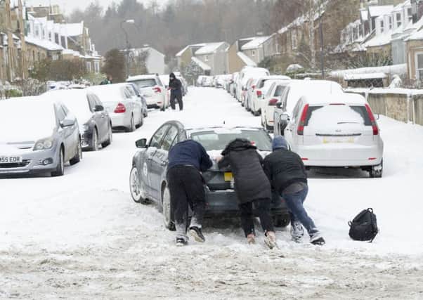 Passers-by help push a motorist stuck in Dalkeith. 
Picture: Ian Rutherford