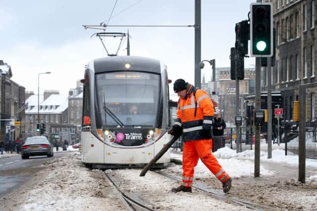 An engineer clears snow and ice from the tram lines along York Place. Picture: Jane Barlow/PA Wire