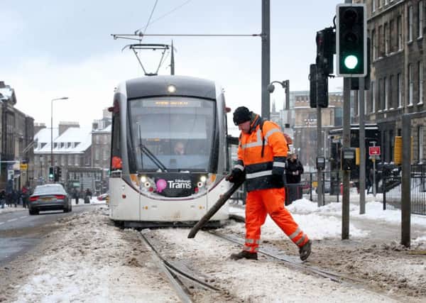 An engineer clears snow and ice from the tram lines along York Place. Picture: Jane Barlow/PA Wire