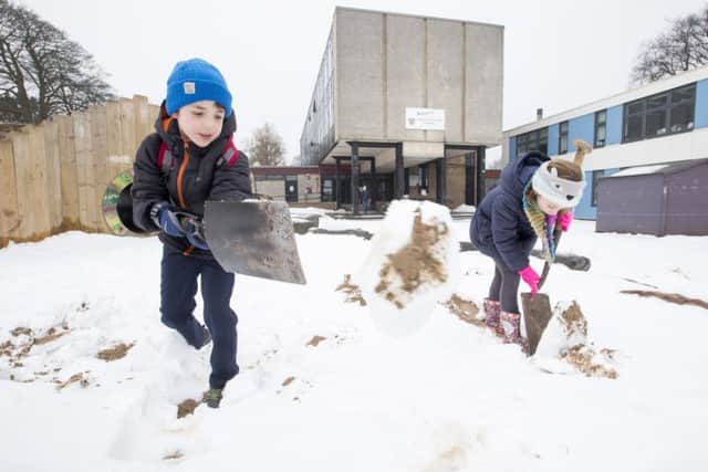 Finlay Johnston,8 and Molly Walsh, 8, help out with the snow clearing party at Trinity Primary School, Edinburgh. Picture: SWNS