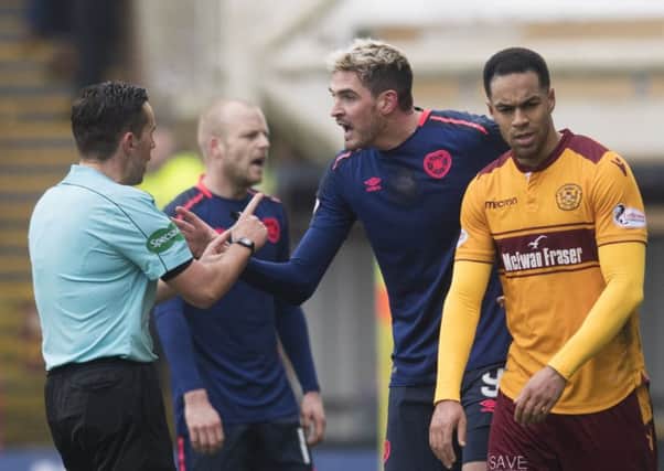 Kyle Lafferty, centre, speaks with referee Andrew Dallas after a challenge on Motherwell's Tom Aldred. Pic: SNS