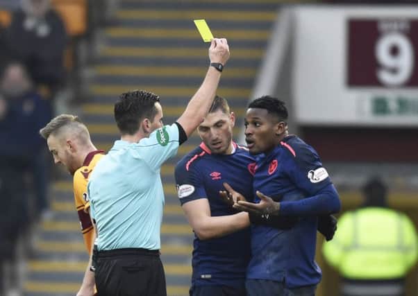 Joaquim Adao is booked by referee Andrew Dallas at Motherwell