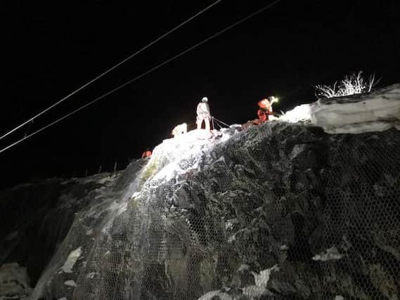 Abseilers working through the night to clear snow from the cutting. Picture: ScotRail Alliance
