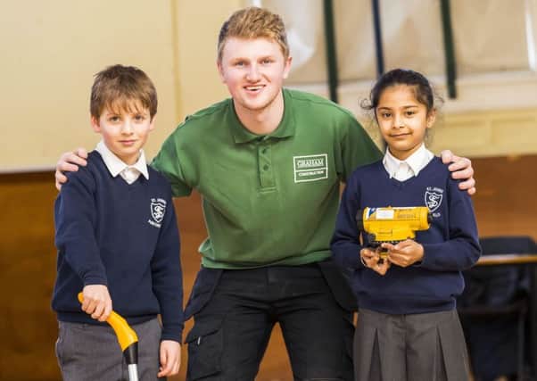 project: Apprentice site manager Greg Wilkinson gives eight-year-old pupils Leandro Forno and Ria Kaur an insight into his work