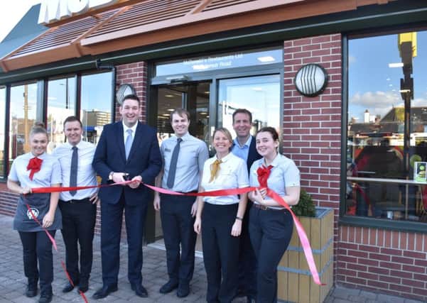 Miles Briggs joins Cameron Fraser and staff to cut the ribbon at a refurbished McDonald's/