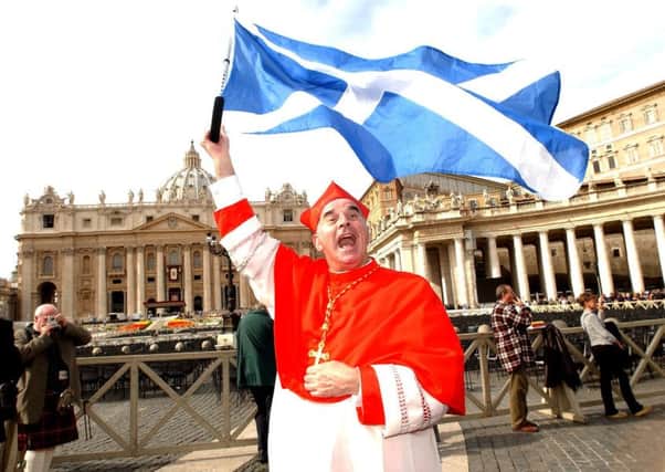 Cardinal Keith O'Brien celebrates in St Peters Square in Rome with the Saltire .
Photo Robert Perry The Scotsman