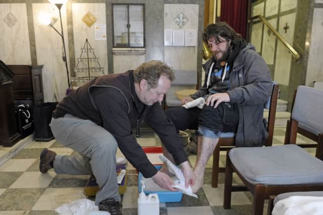 Rev Peter Sutton washes people's feet.


Picture: Neil Hanna
