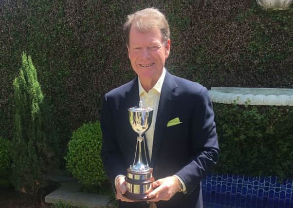 Five-time Open champion Tom Watson shows off the new trophy