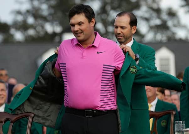 New Masters champion Patrick Reed receives his Green Jacket from 2017 winner Sergio Garcia. Picture: Getty Images