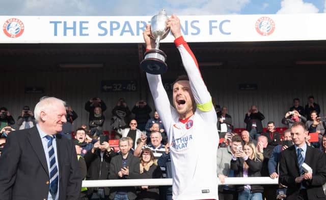Spartans captain Michael Herd lifts the Ferrari Packaging Lowland League trophy. Pic: Ian Georgeson