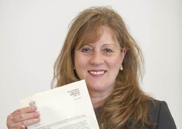 Lynn Cleal pictured in her Edinburgh office with a letter informing her that she is being invited to the  wedding of Prince Harry and Meghan Markle in May. Picture: Ian Rutherford