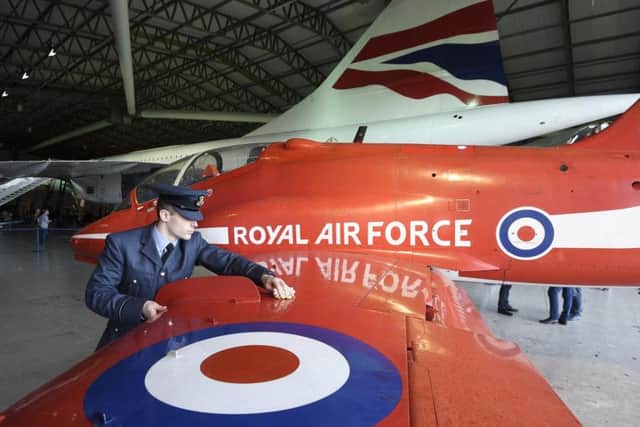 Flying Officer Scott Bagshaw gives the Red Arrow Hawk wing a wipe (PIC: Greg Macvean)