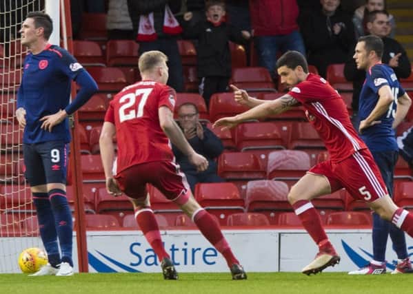Aberdeen's Anthony O'Connor celebrates after making it 1-0 as Hearts' cresfallen players look on. Pic: SNS