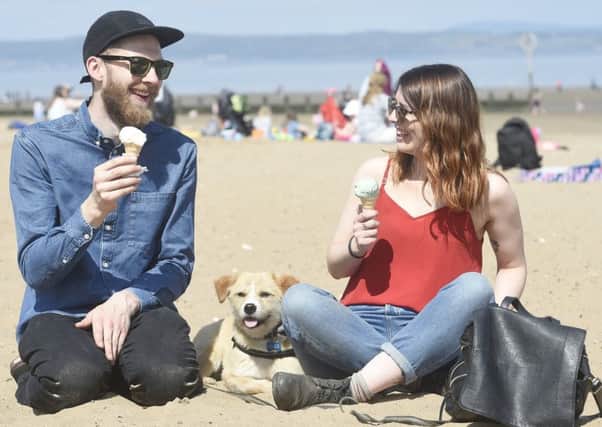 David Bowes and Beth Stanners enjoy an ice cream on Portobello beach in the sunshine with Buffy the dog