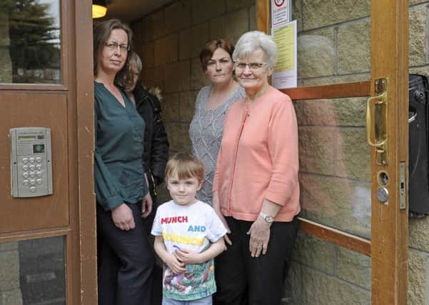 Robertson Gait residents Dorothy Lost (L) and Lorna Greenham (R) with other residents at the broken front door. Picture: Neil Hanna
