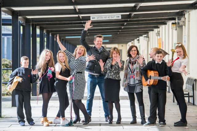 Pupils and staff from Castlebrae Commuity High School celebrate with Fergus Linehan, director of Edinburgh International Festival, centre, after the creation of an arts residency at the school (Picture: Ian Georgeson)