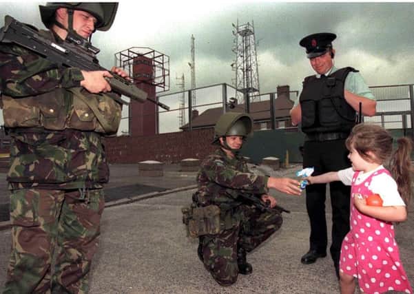 A little girl laughs as she hands a sweet to soldier Tom McMillan in the nationalist Ardoyne area of Belfast.