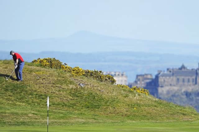 Edinburgh Castle provides a stunning backdrop as RICS' Brian Tait chips at the 17th at the Braids in the first round of the 119th Dispatch Trophy: Picture: Neil Hanna